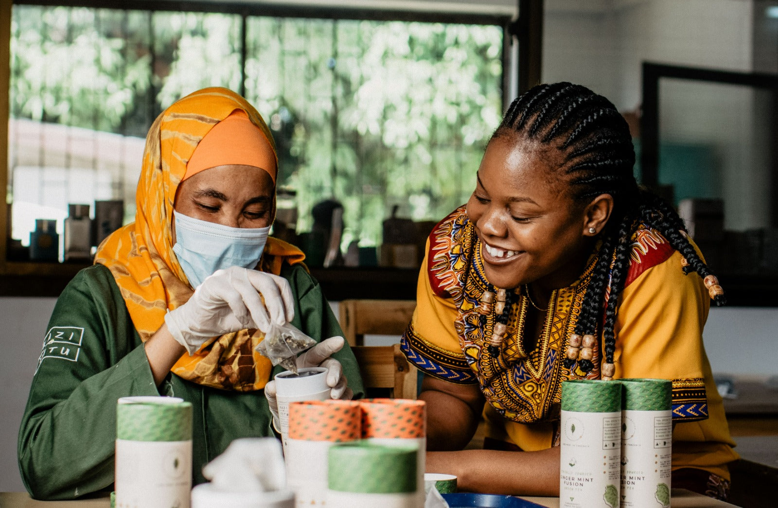 2 Kazi Yetu workers filling Africa Tea Collection tea tubes