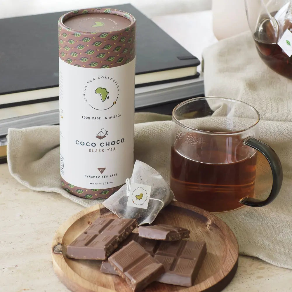 Coco Choco black tea packaging with a cup of tea and chocolate bars on a wooden board.