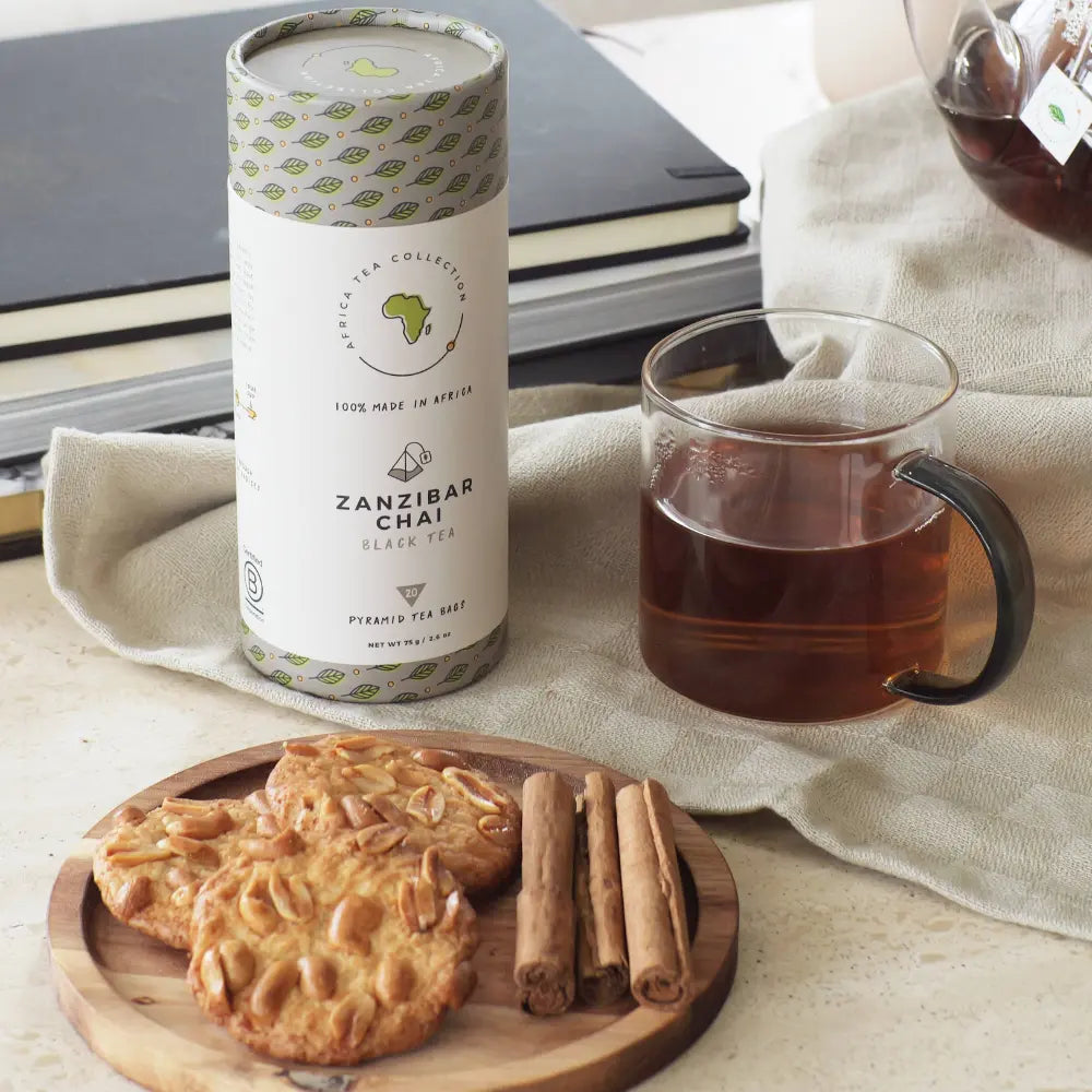 Zanzibar Chai tea packaging with a cup of tea and cookies on a wooden board.