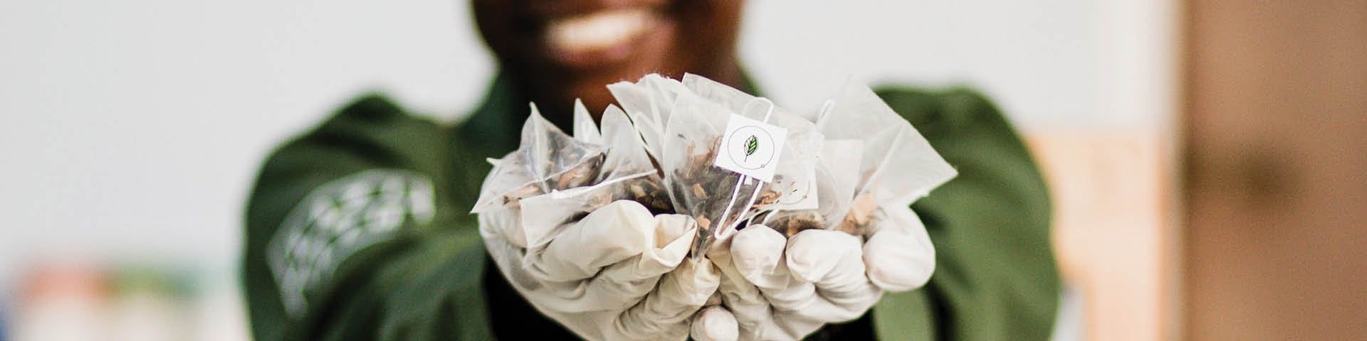 Kazi Yetu employee holding biodegradable pyramid tea bags in her hands