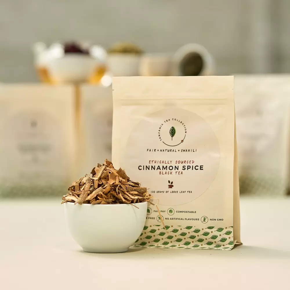 Product picture of handcrafted Cinnamon Spice black tea blend 100 gram loose leaf paper bag and cinnamon bark shavings in a bowl