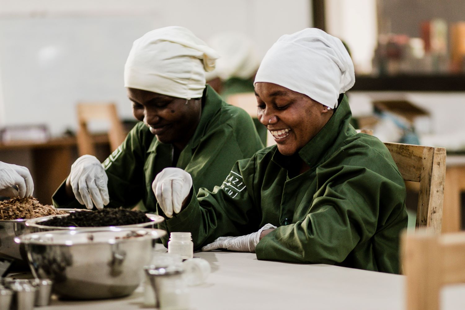 Smiling Kazi Yetu factory workers sorting tea blend ingredients