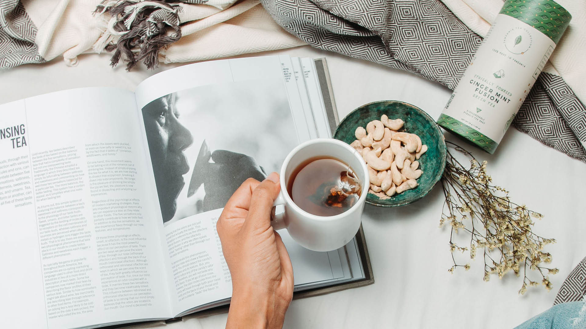 Woman drinking Ginger Mint Fusion tea blend and reading book in bed