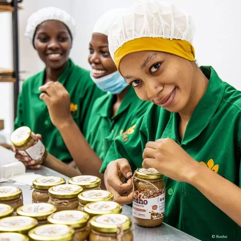 Three female factory workers producing rosho cashew butter jars